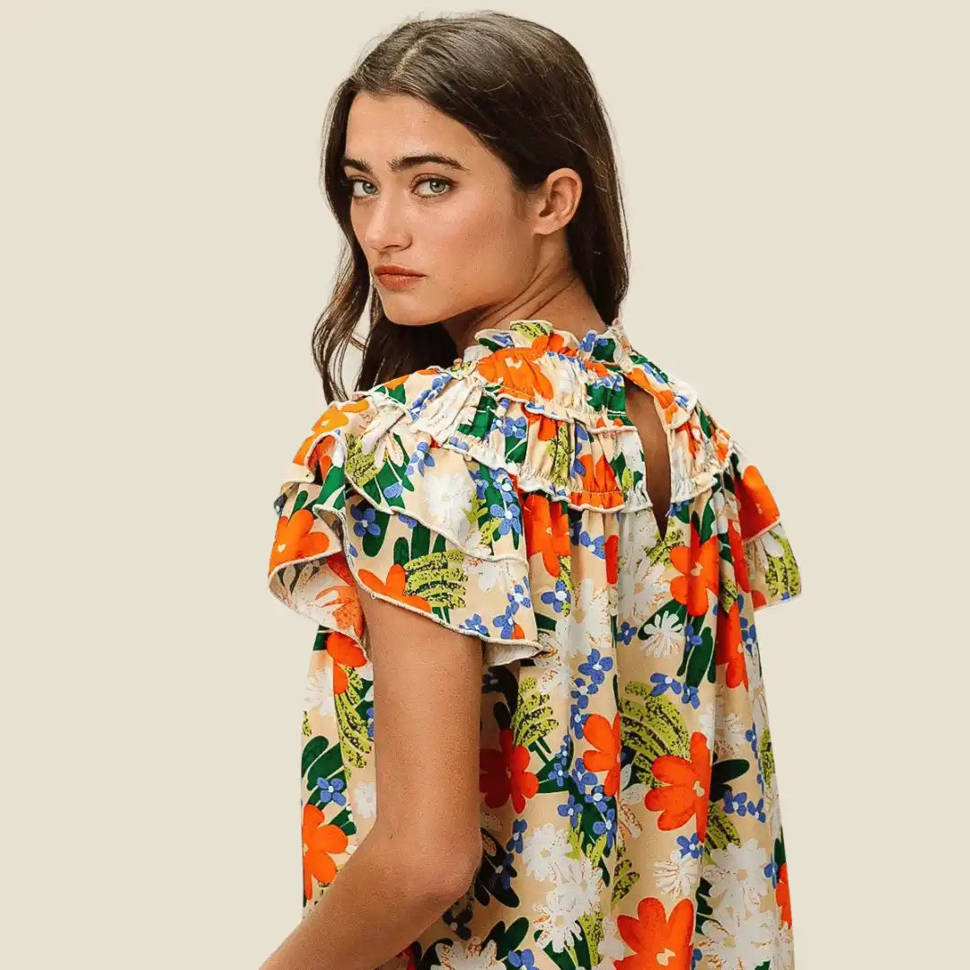 Women’s floral print ruffled blouse with short flutter sleeves.