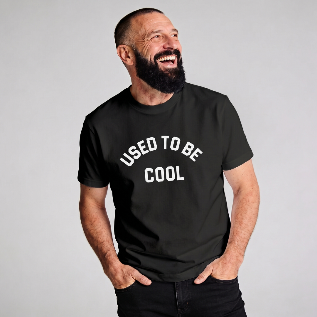 Man wearing a black t-shirt with 'USED TO BE COOL' text on a gray background