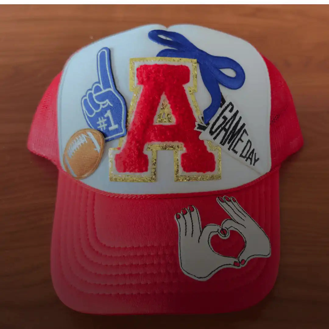 Red and white trucker hat with embroidered sports-themed patches