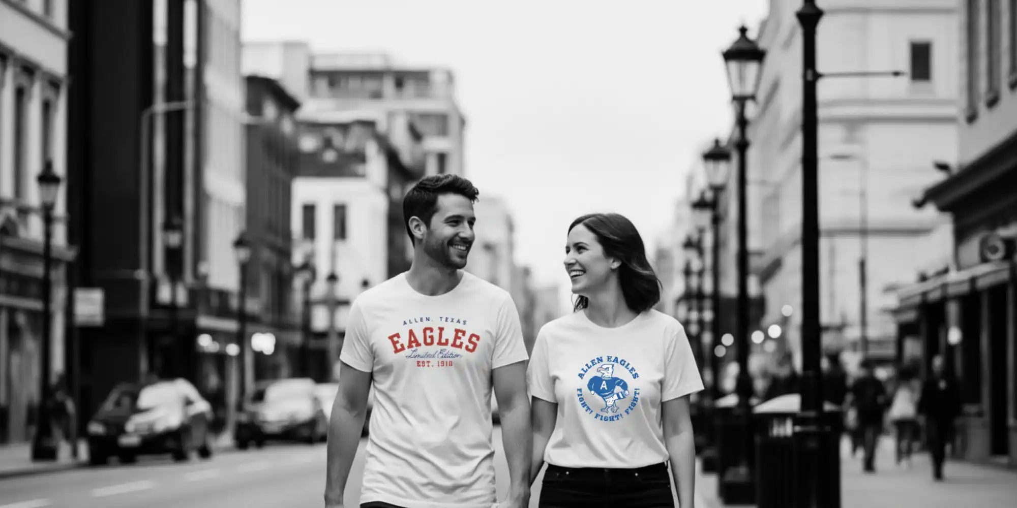 Two people wearing matching t-shirts walking outdoors.