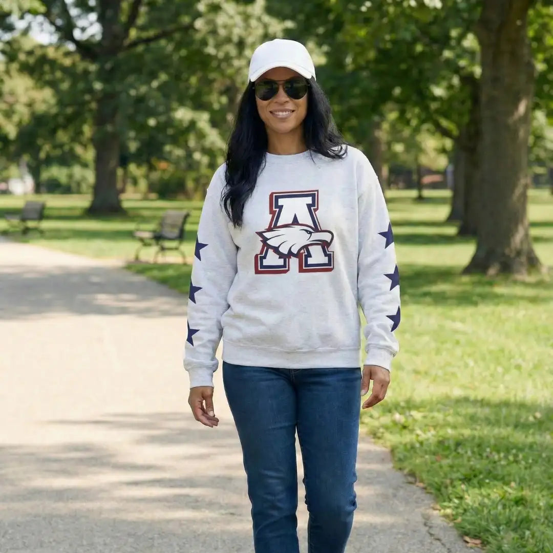 White sweatshirt with a bold red, navy, and white eagle logo on the chest and navy stars along each sleeve.